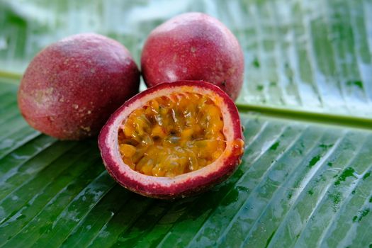 Collection of whole and cut passion fruits (maracuya) isolated on banana leaf. Passion fruit smoothie by fresh ingredient. 