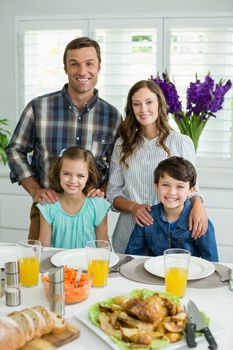 Portrait of smiling family having lunch together on dining table at home