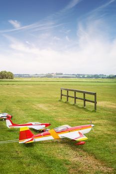 Model airplanes ona line on a green field in the summer under a blue sky