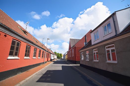 Empty street with red buildings under a blue sky in the summer