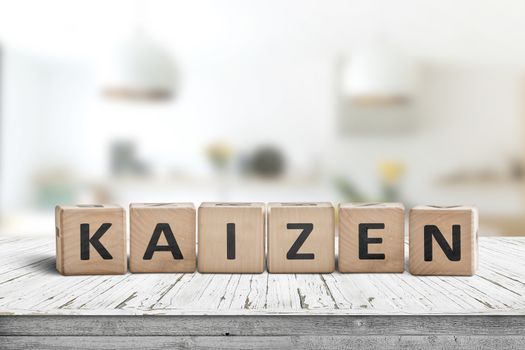 Kaizen improvement sign made of blocks on a wooden desk in a bright room
