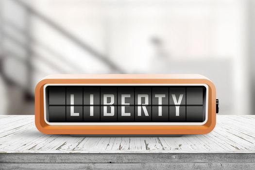 Liberty message on an orange alarm clock in a bright room on a desk