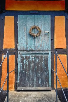 Blue door entrance on a retro facade with orange colors in an old-fashioned style