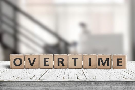 Overtime word spelled with wooden blocks in an office environment
