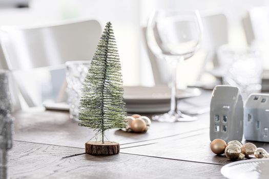Christmas dinner decoration with a Xmas tree and elegant baubles on a table