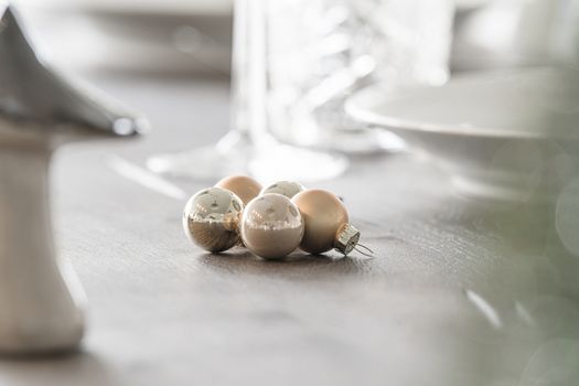 New year ornament with classic baubles on a dinner table in bright daylight