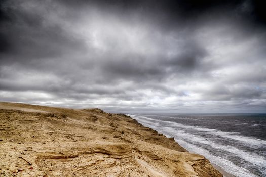 Cloudy weather over a rough coastline by the sea with dark skies