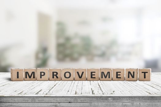 Improvement sign on a wooden office desk in a bright room with green colors