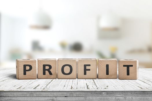 Profit sign in a bright room on a wooden table with white paint