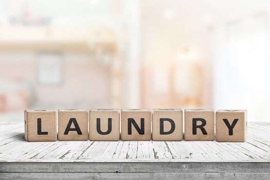 Laundry sign on a white table in a bright living room with sunlight coming in by the window