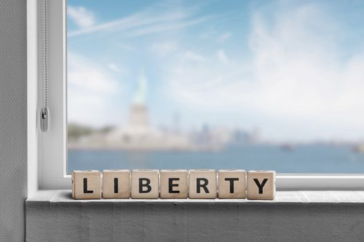 Liberty sign in a window sill with a view to the statue of liberty