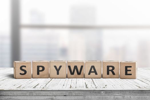 Spyware word on wooden cubes in a bright office on a white painted desk