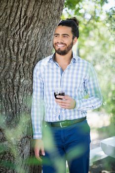 Man holding glass of wine in the park on a sunny day