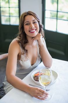 Portrait of woman smiling while holding wine glass in the restaurant