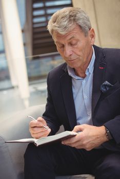 Attentive businessman writing in organizer in office