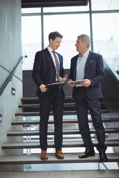 Business executives having a conversation on stairs at office