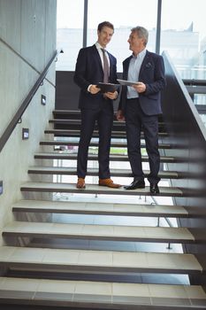 Business executives having a conversation on stairs at office