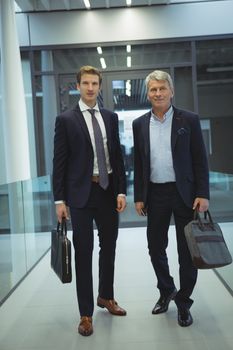 Two businessman standing in corridor at office