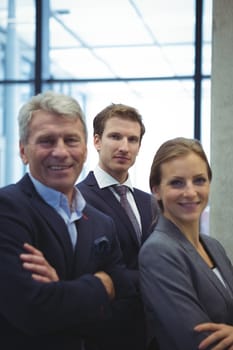 Portrait of business executives standing with arms crossed in the office