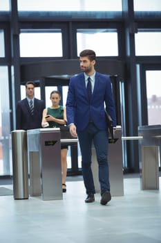 Businessman passing through turnstile gate at office