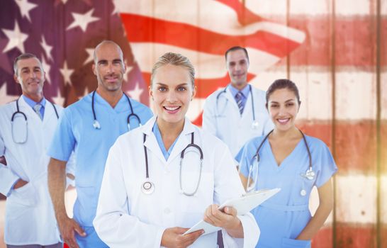 Confident female doctor with team over white background against composite image of focus on usa flag