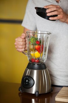 Male staff preparing a juice at health grocery shop