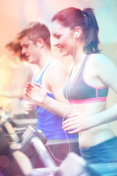 Abstract background against side view of beautiful female athlete standing on running machine listening to music