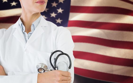 Mid section of a female doctor with stethoscope in hospital against composite image of digitally generated united states national flag