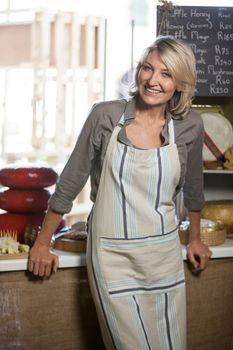 Portrait of female staff standing at counter in supermarket