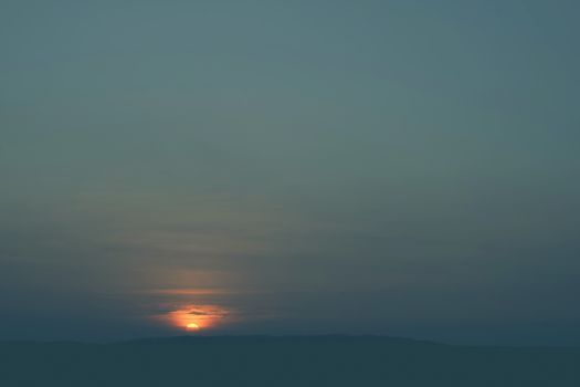 Sunrise over hills covered with trees in the early morning on a countryside scene