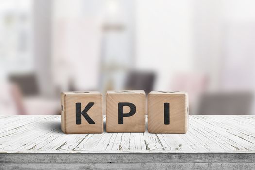 KPI word on a wooden sign in a bright environment with furniture in the background