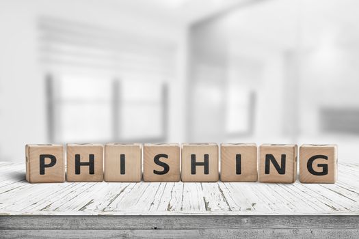 Phishing scam sign on a wooden table in a bright office with blocks