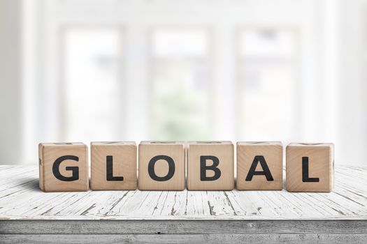 Global sign made of wood in a bright room on a white desk with worn paint