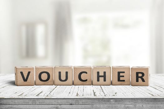 Voucher sign in a bright room on a white painted table made of wood