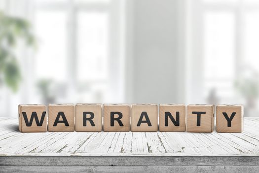 Warranty sign on a wooden desk in a bright environment with green plants