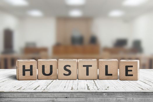 Hustle sign with text on a worn desk in a courtroom with bright lights