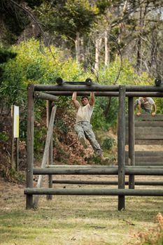 Soldier climbing monkey bars in boot camp