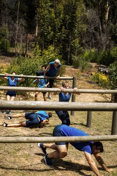 People passing through hurdles during obstacle course in boot camp