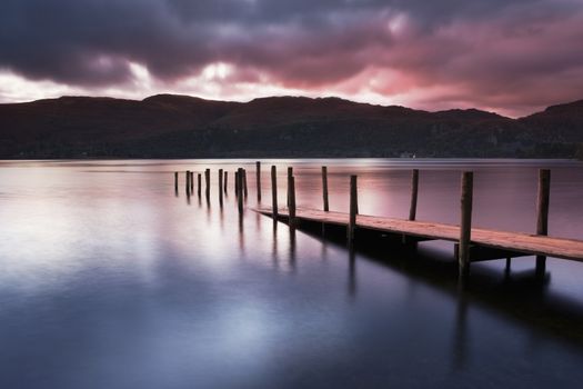 A view across Derwent water lake at dawn, with Jetty in foreground.
Lake District
Cumbria.
England




England