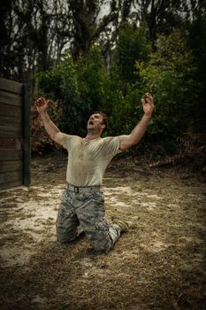 Soldier screaming with arms wide open in boot camp