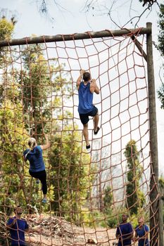 People climbing a net during obstacle course in boot camp