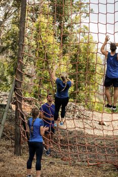 People climbing a net during obstacle course in boot camp