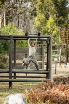 Soldier climbing monkey bars in boot camp