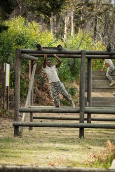 Soldier climbing monkey bars in boot camp