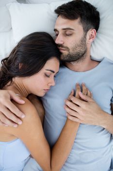 Young romantic couple sleeping on bedÂ in bedroom