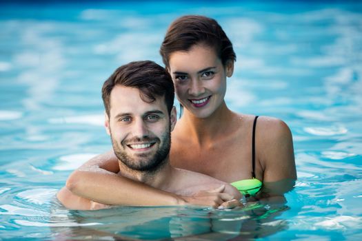 Young romantic couple embracing each other in the pool