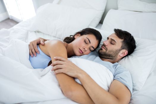 Young romantic couple sleeping on bedÂ in bedroom