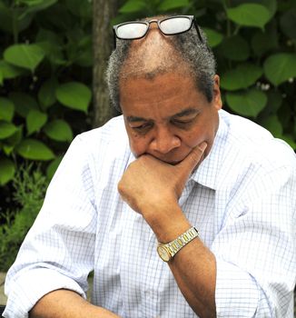 African american male writing on a table outdoors.