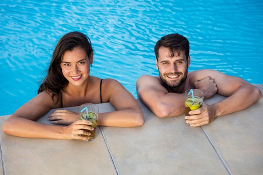 Portrait of young romantic couple relaxing in the pool