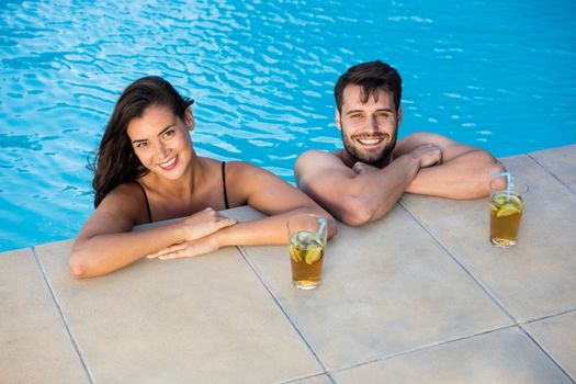 Portrait of young romantic couple relaxing in the pool